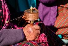 Close-up Hand Of Old Bhutanese Woman Praying In Bhutan. Hand Holding Tibetan Prayer Wheel