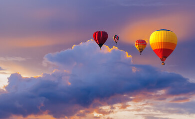 colorful hot air balloon flying above the clouds at sunset time before dark coming with colorful lig