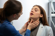 © Ivan - Doctor or ENT doctor checking a young woman's throat with her mouth open.generative ai