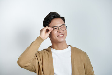 Wall Mural - Handsome stylish young man touching eyeglasses and posing