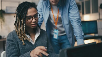 Female programmer talking with an office superior, diverse office team, work