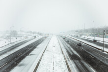 Car Driving On Asphalt Road During Snowfall