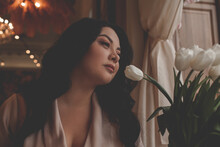 Beautiful Woman Drressed Biege Elegant Suit Sit In Cafe And Drink The Cup Of Coffee. The Plus Size Woman Holding A Bouquet Of Whine Flowers. Happy Overweight Model
