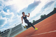 © Panumas - Fit young man running sprinting at the racetrack. Fit runner fitness runner during outdoor workout at racetrack.