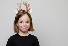 Christmas Portrait Of Happy Child Girl In Xmas Hair Band Santa's Reindeer On White Background