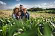 A farming family in the middle of a cornfield smiling for the camera. Generative ai