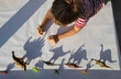 boy draws contrasting shadows from different figures of toy dinosaurs standing in row. little scientist, ideas for development of creative thinking, games for children, passion for paleontology