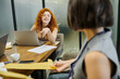 © LIGHTFIELD STUDIOS - redhead businesswoman pointing at blurred colleague with envelops, modern office, laptops, documents