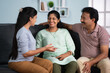 © WESTOCK - Happy smiling indian parents with adult daughter spending time by talking each other at home - concept of communication, family togetherness and weekend holidays.