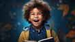 © ND STOCK - Delighted African American boy in glasses laughing for camera and reading book while having fun during school students against blue background