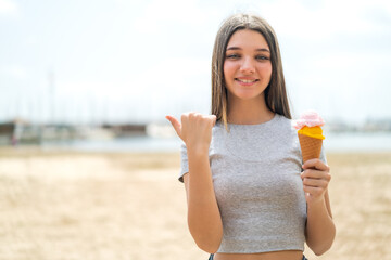 Poster - Teenager girl with a cornet ice cream at outdoors pointing to the side to present a product