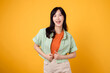 © Jirawatfoto - happiness and well-being with cheerful young Asian woman 30s wearing an orange shirt. Her happy mind wellness gesture on a yellow background captures a profound happiness portrait of contentment.