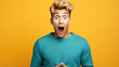 Leinwandbild Motiv Young handsome man wearing casual clothes shocked with surprise and amazed expression on yellow background