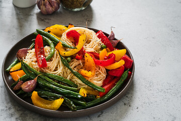 Wall Mural - Plate of pasta with roasted  vegetables, green bean, red and yellow bell pepper, garlic