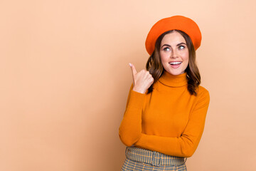 Sticker - Photo of charming positive lady wear fall orange trendy clothes finger direct empty space look up offer isolated on beige color background