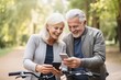 happiness adult mature old age retired couple hand using smartphone application checking route map location while riding exercise bicycle morning garden park freshness healthy concept
