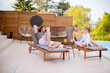 © BGStock72 - Family with a mother, father and daughter sitting on the deck chairs by the swimming pool