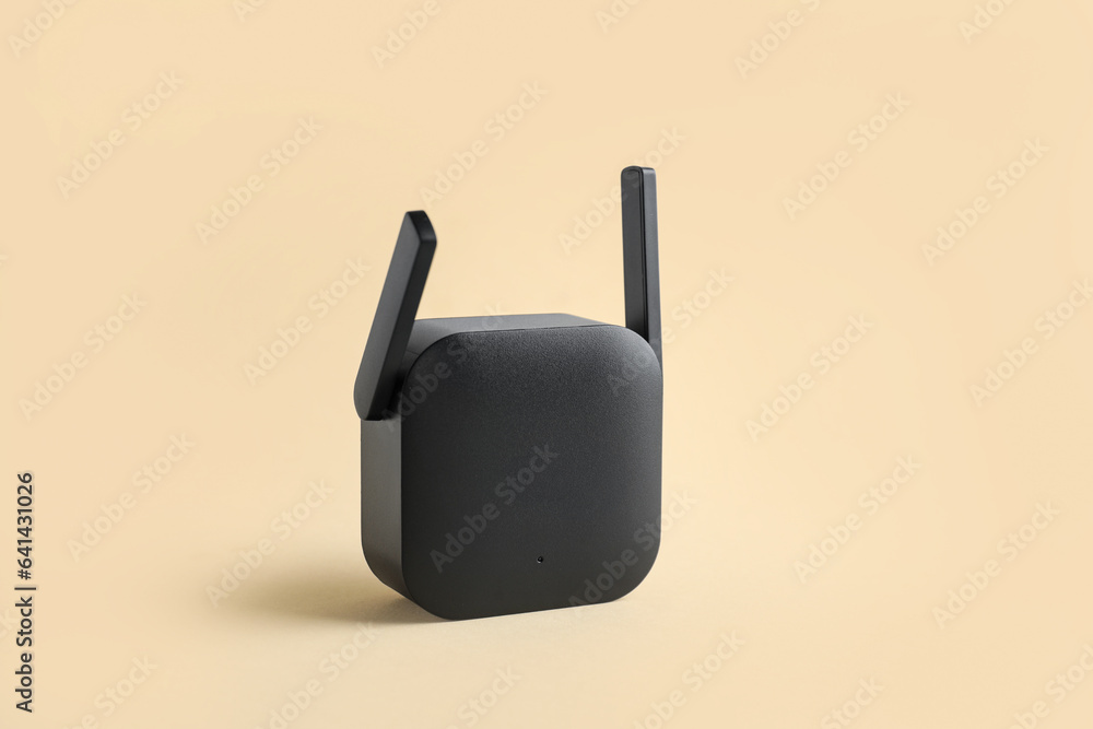 Black WiFi repeater on beige background