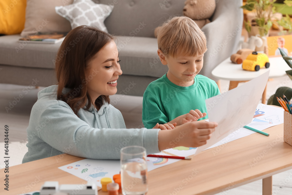 Nanny with little boy drawing at home
