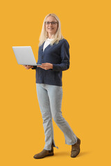 Sticker - Mature female programmer working with laptop on yellow background