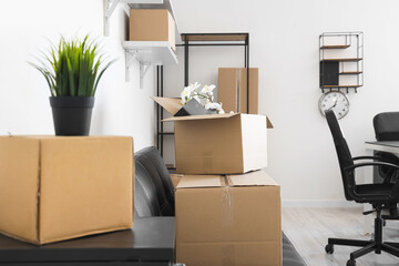 Wall Mural - Cardboard boxes with houseplant and personal belongings in office on moving day