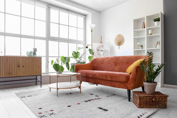 Sticker - Interior of light living room with brown sofa and coffee table near big window