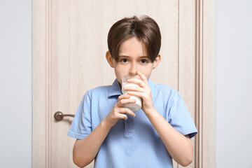 Sticker - Little boy drinking fresh milk near door in room