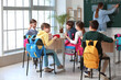 © Pixel-Shot - Little pupils with backpacks having lesson in classroom