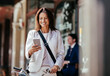 © Marko Geber - Mature caucasian businesswoman using a smart phone while commuting to work with a bicycle