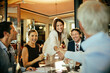 © Marko Geber - Group of business people having a meeting in a cafe bar
