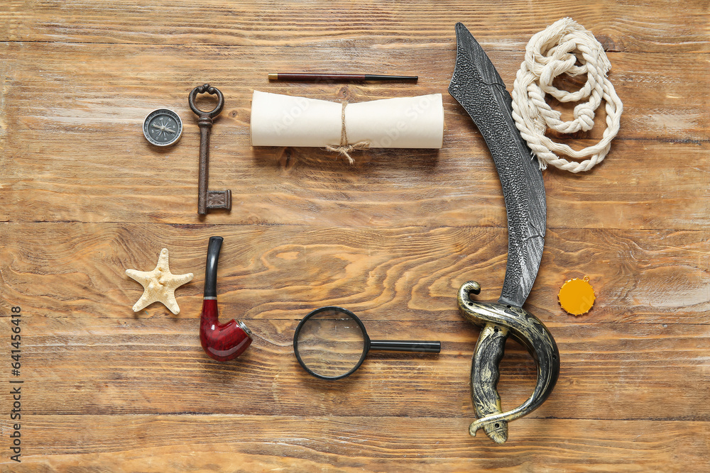 Different pirate equipment on brown wooden background