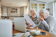 © Marko Geber - Senior couple having breakfast and going over their bills and home finances in the kitchen in the morning