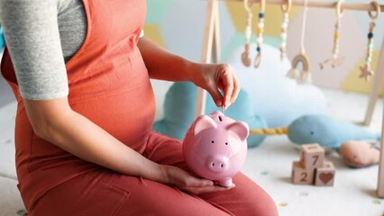 Wall Mural - Pregnancy family planning budget. Cost of having a child. Pregnant woman putting money in piggy bank shopping newborn toys and nursery decor with savings. Maternity leave benefits.