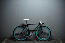 Retro Bicycle With Blue Rims Parked In Underground Garage Against Gray Concrete Wall Background  