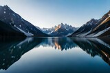 Fototapeta Góry - A tranquil lake surrounded by snow-covered peaks, the mirror-like surface reflecting the serenity of the scene
