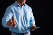 Biracial businessman using smartphone and pointing on black background