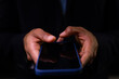 Hands of biracial businessman using smartphone with copy space on black background