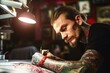 A tattooed man writing on a piece of paper