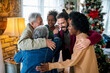 © NDABCREATIVITY - Cheerful extended multiethnic family having fun while celebrating Christmas together at home.