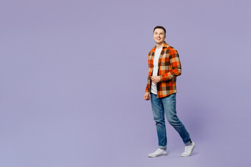 Wall Mural - Full body young happy man he wears checkered shirt white t-shirt casual clothes walking going look camera strolling isolated on plain pastel light purple background studio portrait. Lifestyle concept.