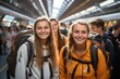 © DenisNata - Friends girls with backpacks at railway station waiting for train. Smiling Girls tourists or students ready for trip.