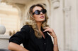 © Svetlana Sokolova - Elegant luxury blond woman with perfect wavy hairs , make up , sunglasses posing outdoor. Casual outfit.