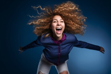 Wall Mural - Headshot portrait photography of a joyful girl in her 20s jumping with joy against a navy blue background. With generative AI technology