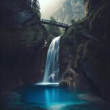 Fototapeta Natura - A waterfall in the mountains with a blue pool and a bridge in the foreground