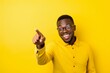 © Markus Schröder - Lifestyle portrait photography of a happy boy in his 30s pointing empty space against a bright yellow background. With generative AI technology