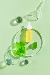 Poster - Dropper bottle without label filled with yellow liquid decorated with glass balls and green leaves. Fish mint (Houttuynia cordata) has an important role to play