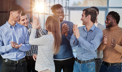 Human resources. Group portrait of smiling employees of a friendly team of different racial genders standing together in an office.