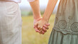 © lenblr - Couple of man and woman walk hand in hand across field on blurred background in warm season. Concept of love and interactions with partner, sunlight