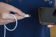 Kobieta podłączająca kabel od ładowarki USB typu c do telefonu