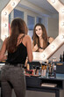 © ADDICTIVE STOCK CORE - Happy young woman standing near visage table